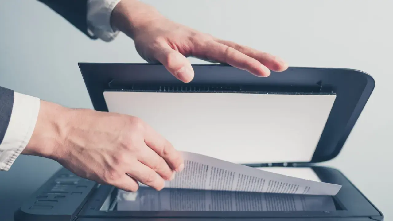 Un homme en costume utilise un scanner ged pour numériser un document important.