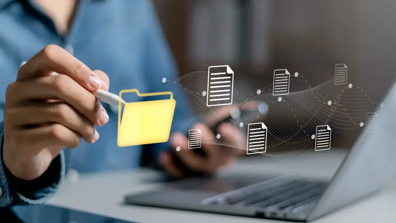 Main d'une personne utilisant un stylet pour interagir avec une icône de dossier jaune, symbolisant la digitalisation des processus et le flux de documents numériques.