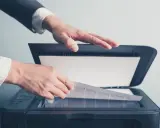 Un homme en costume utilise un scanner ged pour numériser un document important.