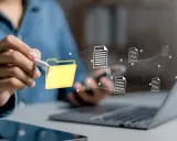 Main d'une personne utilisant un stylet pour interagir avec une icône de dossier jaune, symbolisant la digitalisation des processus et le flux de documents numériques.
