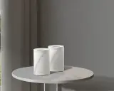 Un routeur extérieur sur un poteau et deux routeurs Deco sur une table. Ces appareils connectent votre maison à Internet.