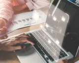 Des mains travaillent sur un ordinateur portable affichant une structure de dossiers numériques, symbolisant les sae archives.