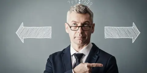 Un homme d'affaires réfléchit, entouré de points d'interrogation et de flèches. Il cherche la meilleure solution, peut-être avec un logiciel GED.
