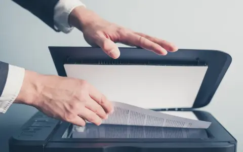 Un homme en costume utilise un scanner ged pour numériser un document important.