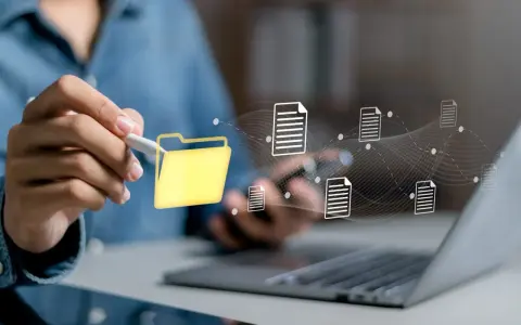 Main d'une personne utilisant un stylet pour interagir avec une icône de dossier jaune, symbolisant la digitalisation des processus et le flux de documents numériques.