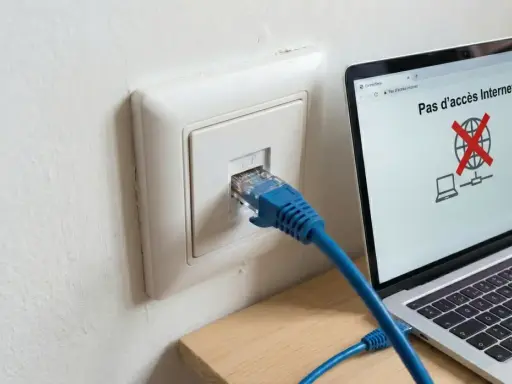 Câble RJ45 branché sur une prise murale, mais l'ordinateur affiche "Pas d'accès Internet". Problème de connexion réseau, peut-être un switch RJ45 sans alimentation.