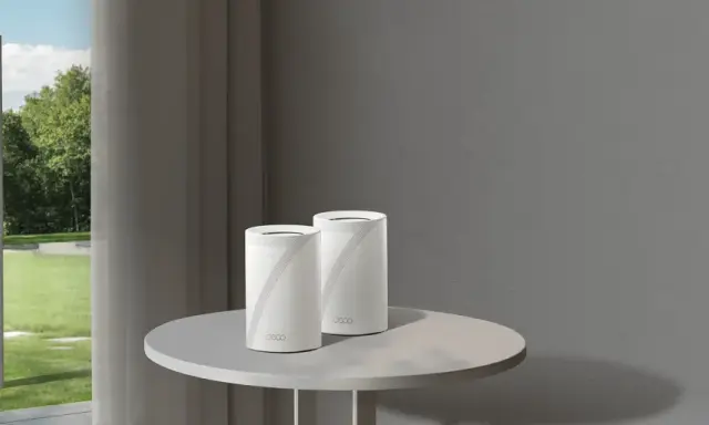 Un routeur extérieur sur un poteau et deux routeurs Deco sur une table. Ces appareils connectent votre maison à Internet.