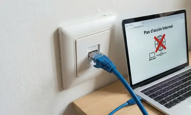 Câble RJ45 branché sur une prise murale, mais l'ordinateur affiche "Pas d'accès Internet". Problème de connexion réseau, peut-être un switch RJ45 sans alimentation.