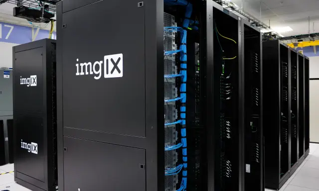 Des racks de serveurs noirs, dont un avec le logo "imgIX", remplis de câbles bleus et jaunes. C'est un peu ça, un serveur : le cœur de l'internet.