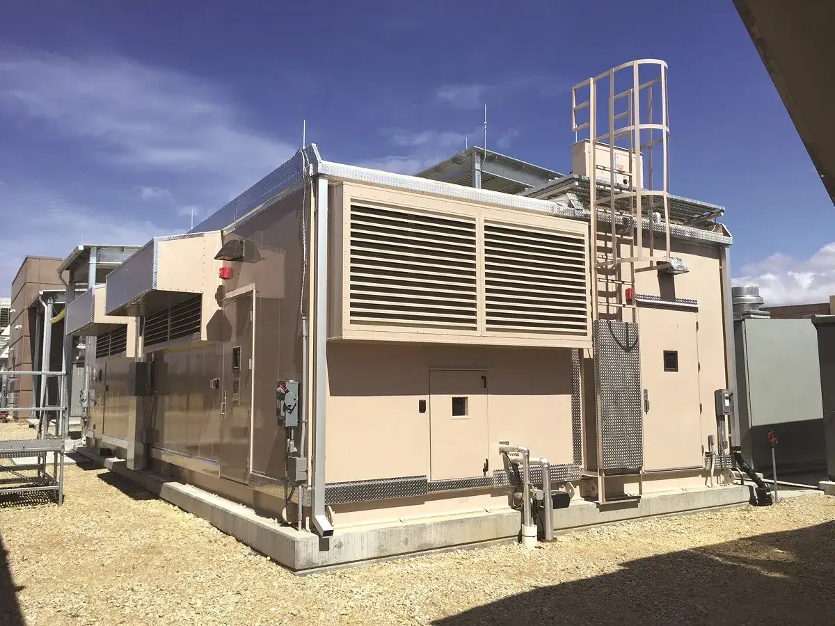 Un data center extérieur moderne avec des unités de climatisation imposantes et une échelle menant au toit.