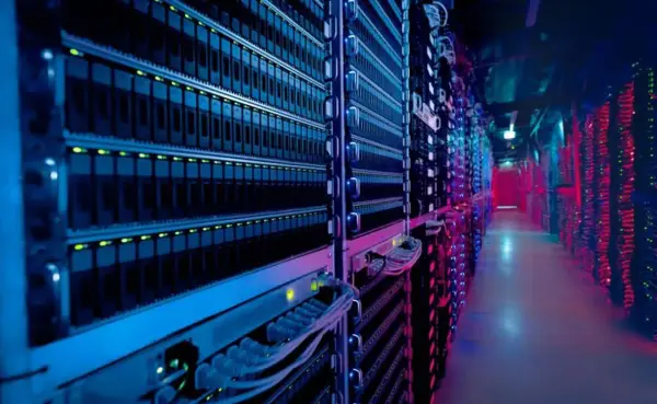 Allées d'un centre de données illuminées par des lumières bleues et rouges, montrant des rangées de 3 types de serveurs.