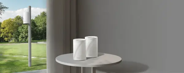 Un routeur extérieur sur un poteau et deux routeurs Deco sur une table. Ces appareils connectent votre maison à Internet.